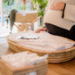 Person sitting on a woven chair with a cushioned seat, surrounded by natural light. | Baby Essentials | All Baby Products | Soft Spot Kids | South Africa