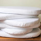 Stack of white mattress toppers on a wooden surface with a neutral background | Baby Essentials | All Baby Products | Soft Spot Kids | South Africa