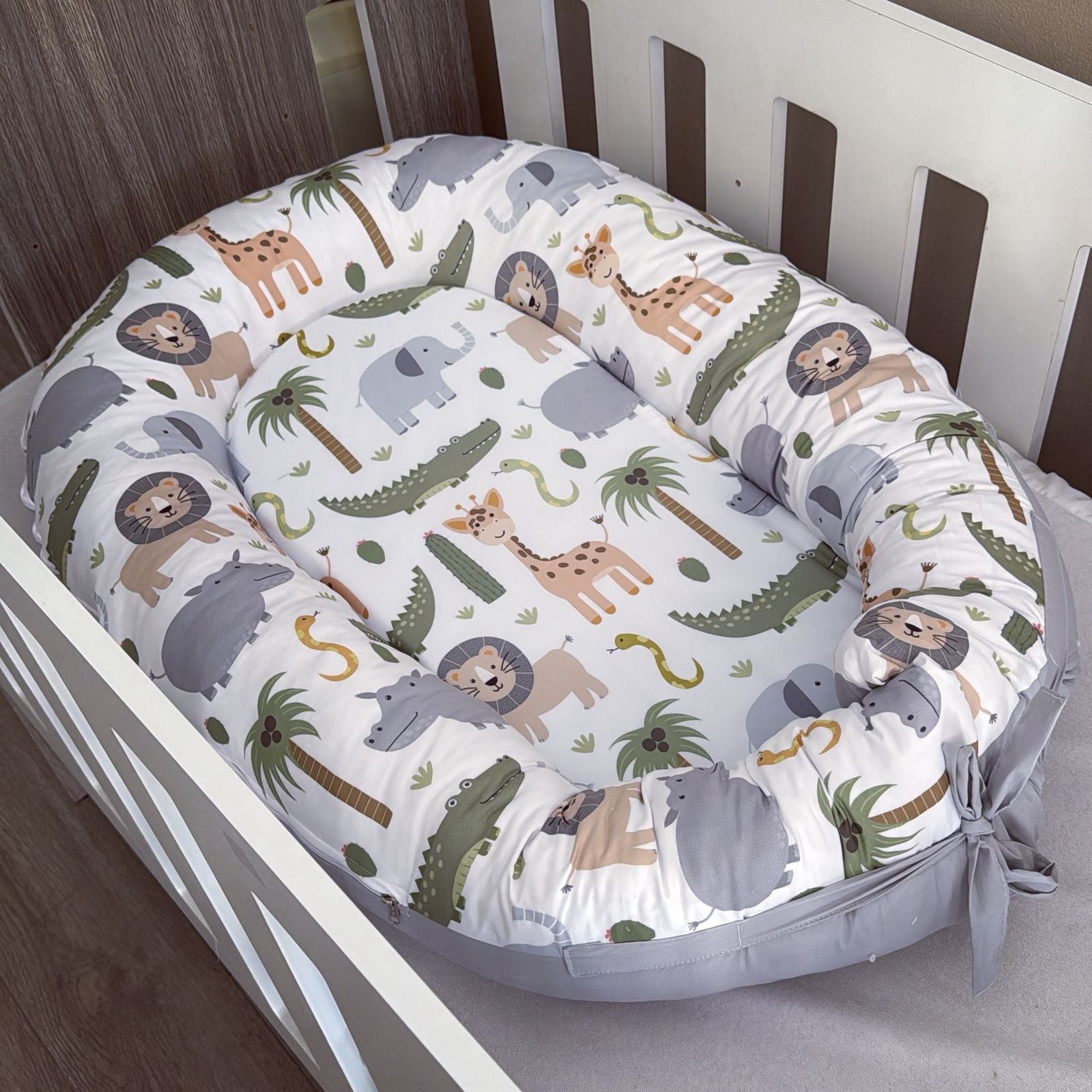 Baby nest with animal pattern in a crib