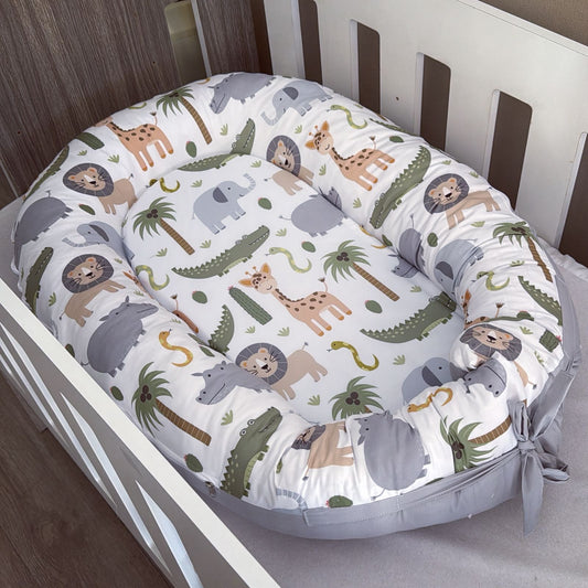Baby nest with animal pattern in a crib