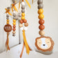 Wooden hanging baby wall decor with colorful beads, yellow and orange ribbons, a round 'WILD of heart' sign, and a lion face cutout on a white wall. | Baby Essentials | All Baby Products | Soft Spot Kids | South Africa
