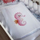 White pillow with a pink seahorse design on a bed with white pillows and a wooden sideboard. | All Nursery Sets | Baby Bedding Sets South Africa | Soft Spot Kids | South Africa