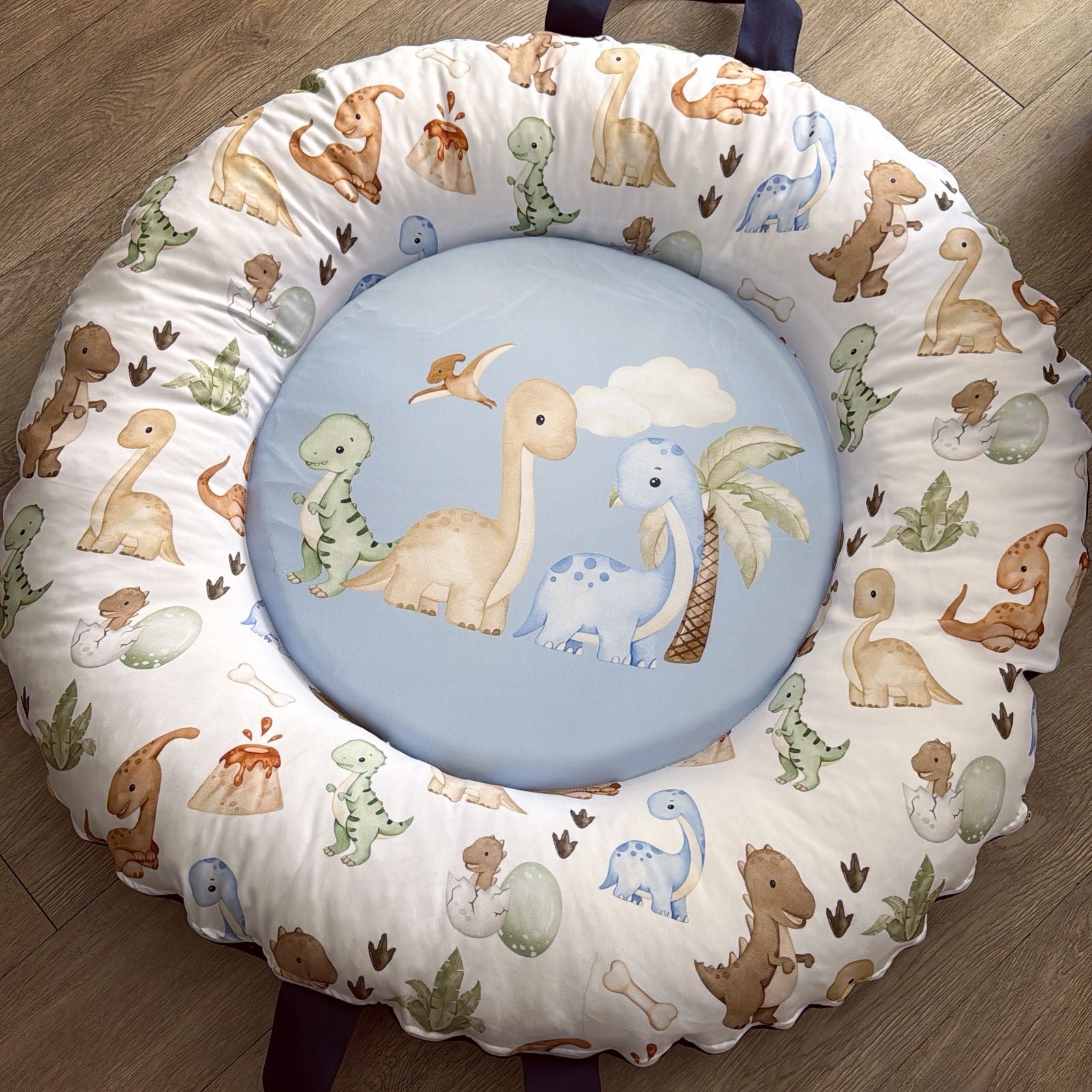 Round cushion with dinosaur pattern on a wooden floor