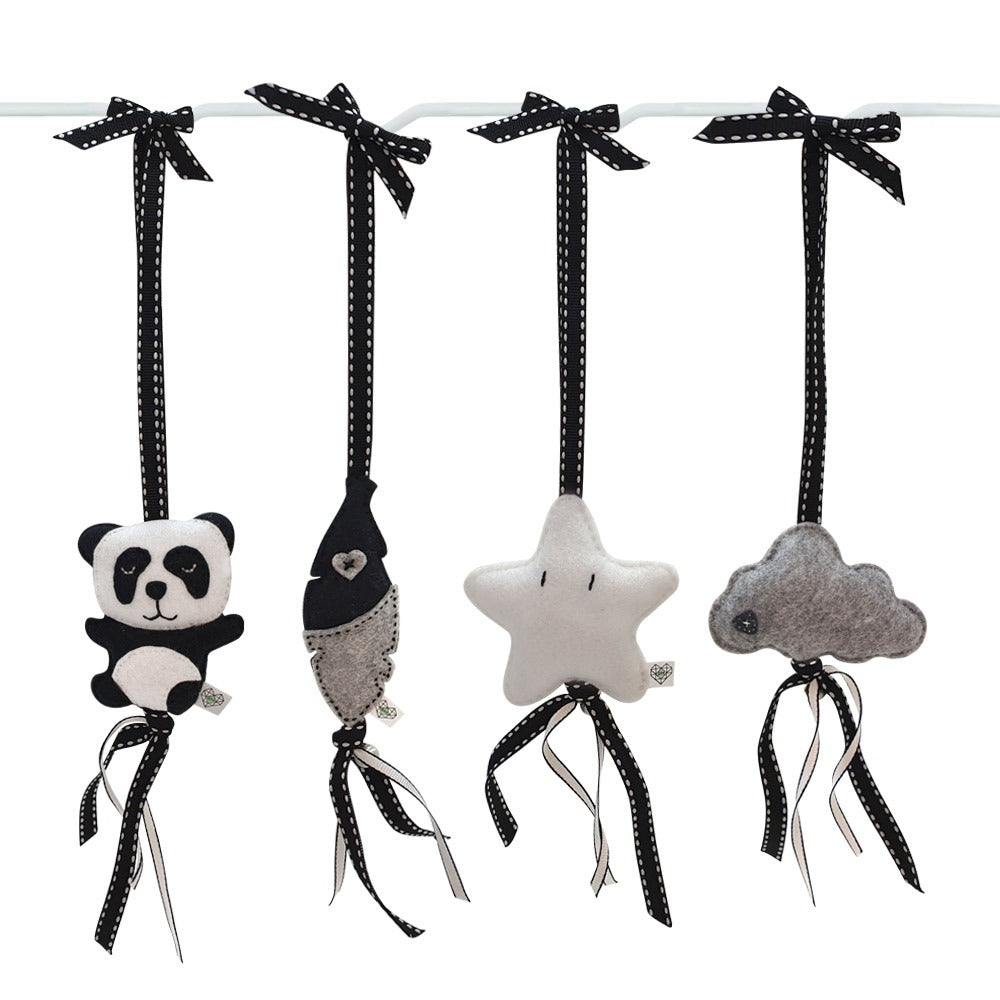 Four black and white fabric hanging baby toys shaped like a panda, a fish, a star, and a cloud, each attached to a black ribbon bow on a white rod against a white background.