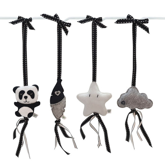 Four black and white fabric hanging baby toys shaped like a panda, a fish, a star, and a cloud, each attached to a black ribbon bow on a white rod against a white background.