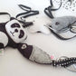 Three handmade felt baby toys with black and white polka-dot ribbon ties, including a panda, a star, and a whale, arranged on a white fabric background. | Baby Essentials | All Baby Products | Soft Spot Kids | South Africa