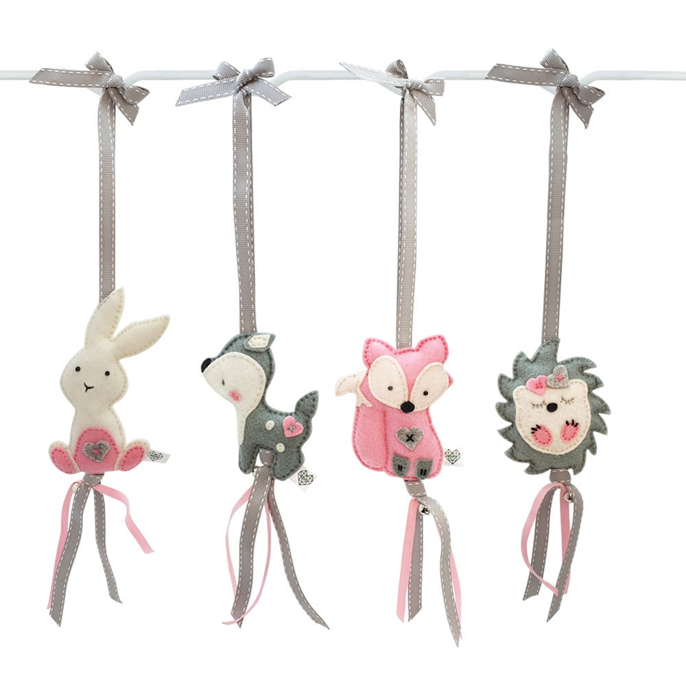 Four felt animal hanging ornaments on a white rod, including a white bunny with pink ears, a gray fox with pink accents, a pink fox, and a gray hedgehog with pink details, each tied with a gray ribbon.