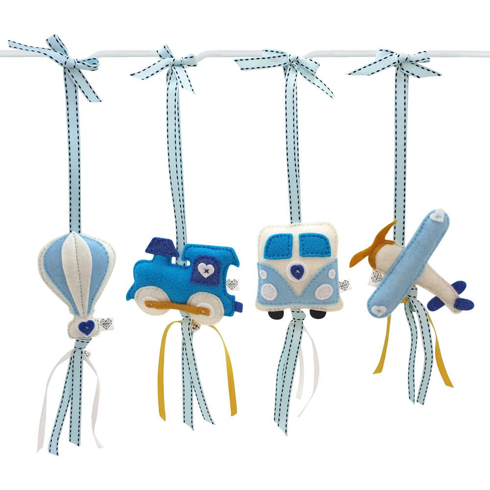 A set of four blue and white felt baby car and plane ornaments hanging from a white rod with light blue dotted ribbons, on a white background.